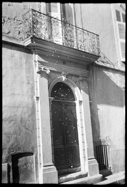 Portail sur rue et balcon en fer forgé qui la surmonte.