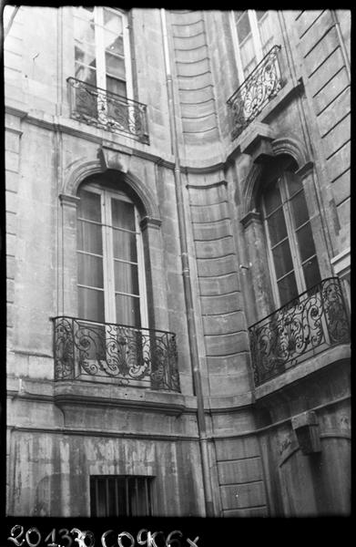 Façade sur rue, renfoncement, fenêtres avec balcon.