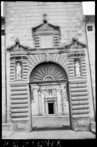 Tour carrée de l'entrée vers la cour d'honneur : portail à bossages et porte vde l'église en arrière plan.