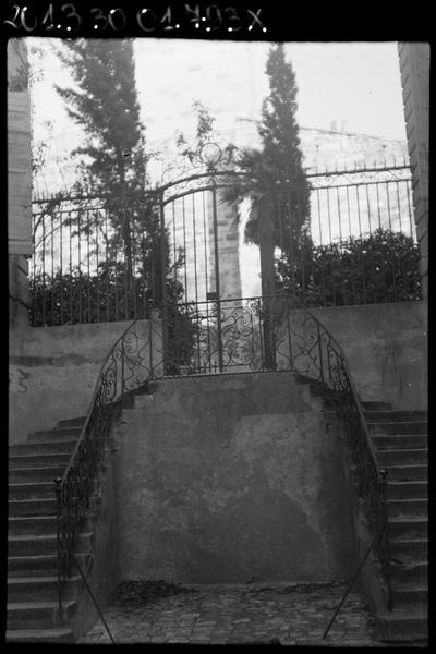 Rampe en fer forgé de l'escalier extérieur entre cour et jardin et grille du jardin.