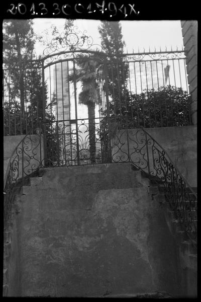 Rampe en fer forgé de l'escalier extérieur entre cour et jardin et grille du jardin.