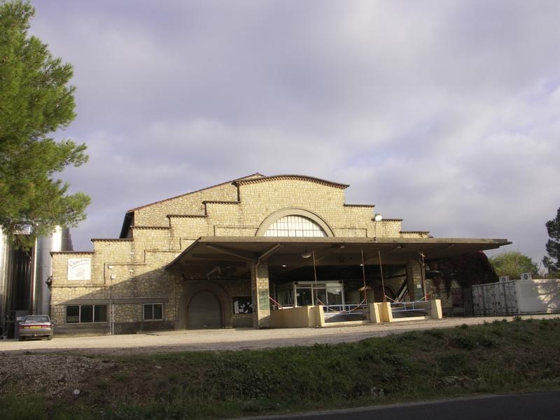 Façade avec l'auvent en béton protégeant les quais de déchargement et l'étagement des volumes.