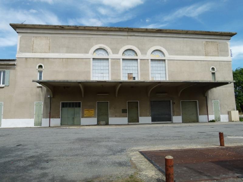 Façade avec l'auvent en béton protégeant les quais de déchargement, vue depuis la bascule.