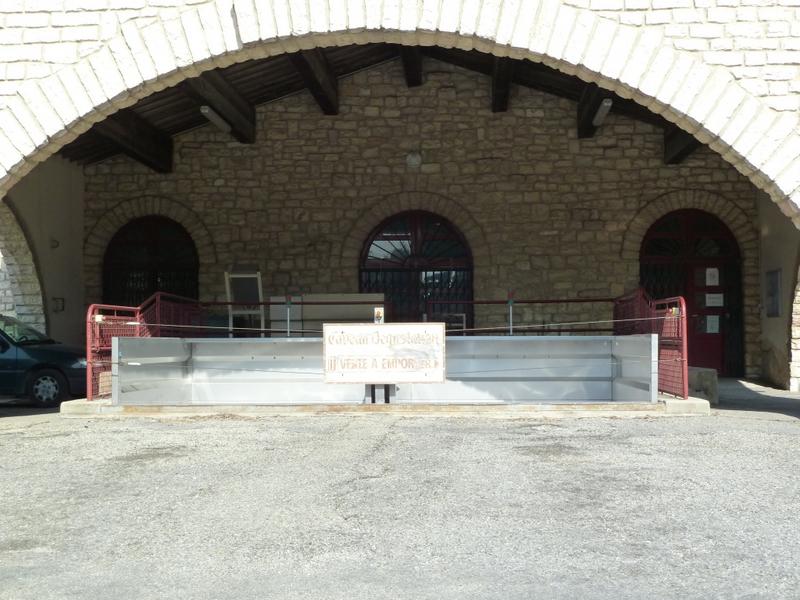 Façade de la cave d'origine : quais de déchargement sous l'auvent en pierre.