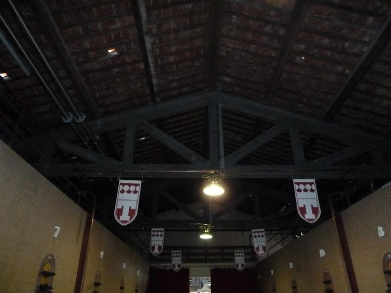 Intérieur de la cave d'origine : travée de cuves, charpente en béton imitant le bois.