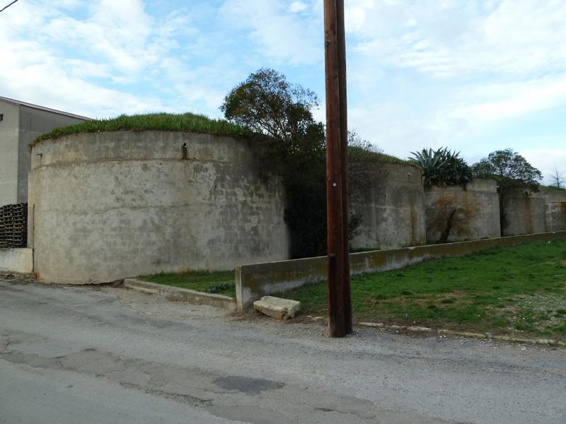 Cuves cylindriques semi-enterrées en ciment situées à l'arrière de la cave et à proximité de l'église.