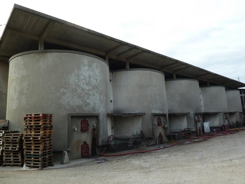 Façade latérale nord : l'auvent en béton est soutenu par des piliers posés sur les cuves rondes en ciment.