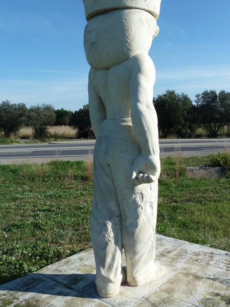 Statue de porteur sculptée par Armand Pellier et déplacée en 2007 devant le caveau d'Héraclès construit sur la R.N. 113 ; vue arrière.