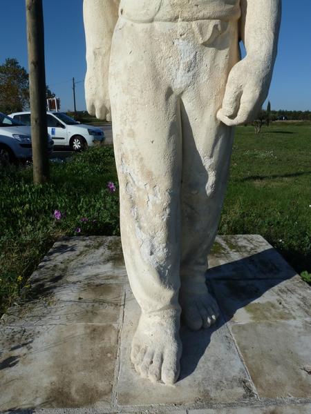 Statue de porteur sculptée par Armand Pellier et déplacée en 2007 devant le caveau d'Héraclès construit sur la R.N. 113 ; détail des pieds nus.