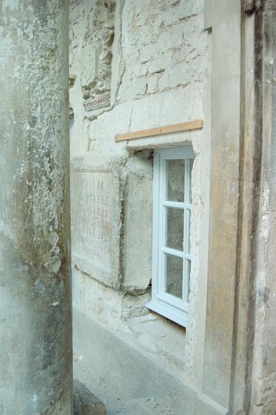 Fenêtre et pierre avec inscriptions romaines.