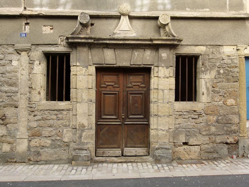 Façade principale. Porte d’entrée entourée de fenêtres qui étaient pourvus de volets en bois aux motifs XVIIe.