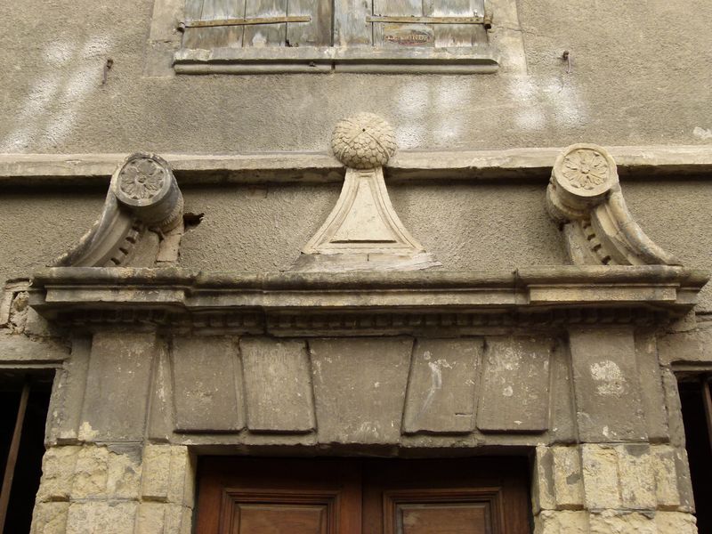 Façade principale. Porte d’entrée. Fronton à volutes interrompu.