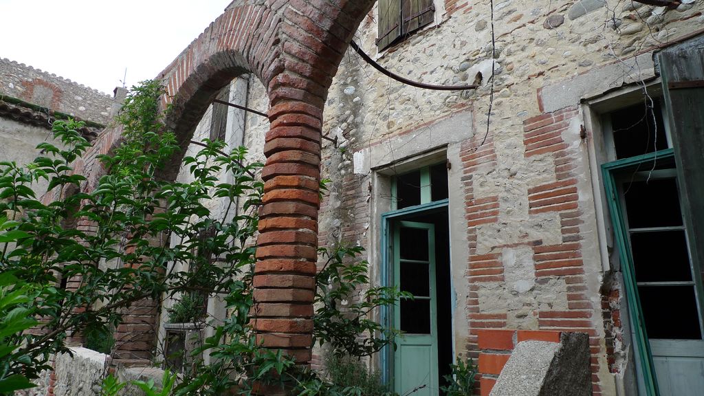 Cour intérieure. Façade sud. Galerie. 1er étage. Murs en briques et galets.