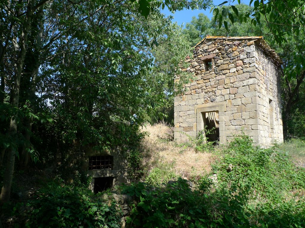 La cabane et l'entrée de la salle de captation, vue depuis la rivière de la Thongue.