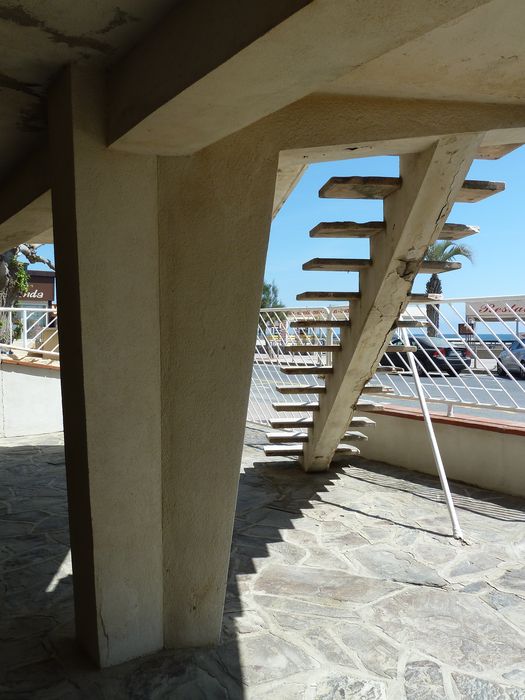 L’escalier placé en diagonale vient en buté contre le muret de clôture. Le pilier central est de section polygonale