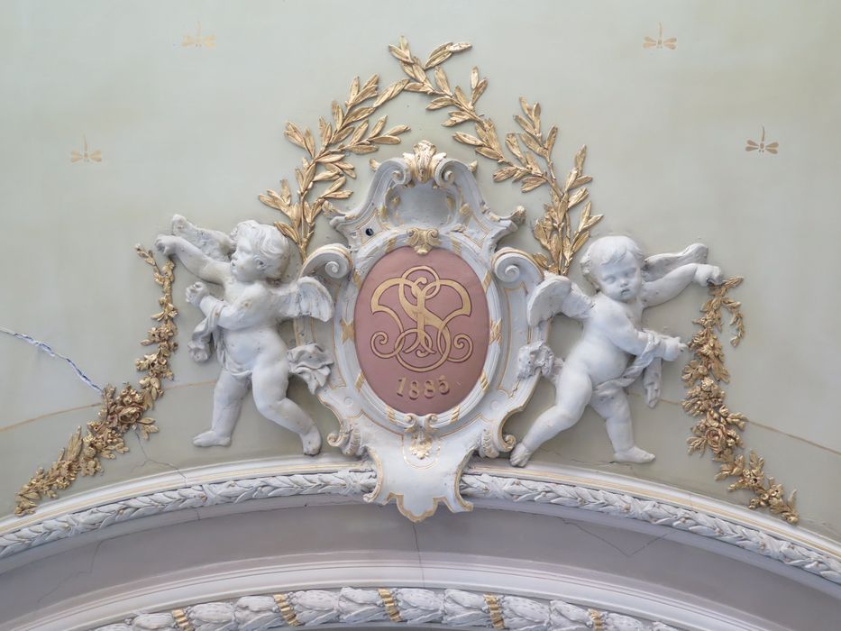 Salle des fêtes du 1er étage. Décor du plafond. Médaillon portant les initiales de Michel Sabatier et la date de 1885 (date de création de la distillerie), encadré d'angelots et de guirlandes.