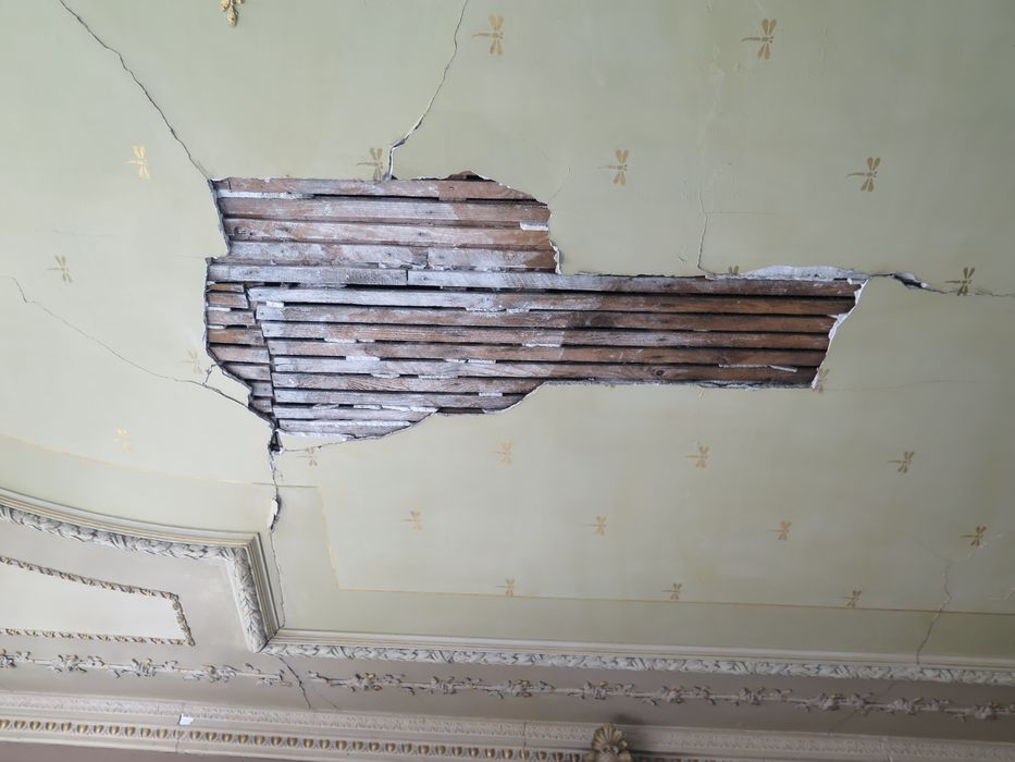 Salle des fêtes du 1er étage. Décor du plafond. Le plâtre est tombé au centre de la pièce laissant visible le lattis de bois.