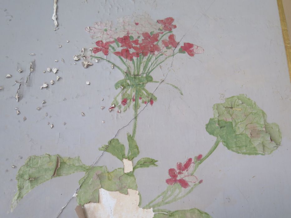 Salle des fêtes du 1er étage. Mur est. Panneau peint avec chute en stuc, tambourin et instrument à vent. Détail de la peinture.