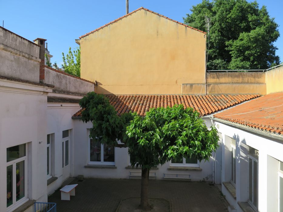 Cour intérieure. Au sud de la cour,s'élève l'aile est du groupe scolaire Jean Jaurès (murs jaunes).