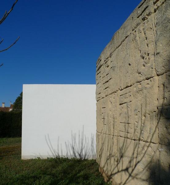 Opposition d'un mur en croûte de pierre du Pont du Gard et d'un mur en béton peint en blanc, à l'arrière de la villa.