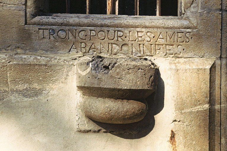 Tronc, à gauche de l'entrée.