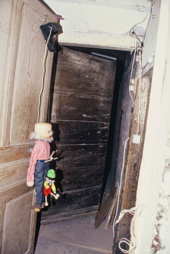 Demi-étage, porte sur couloir menant à la salle au plafond peint.