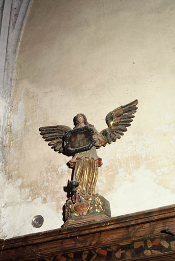 Ange reliquaire posé sur les boiseries du choeur.