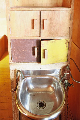 Intérieur du cabanon, lavabo et rangements.