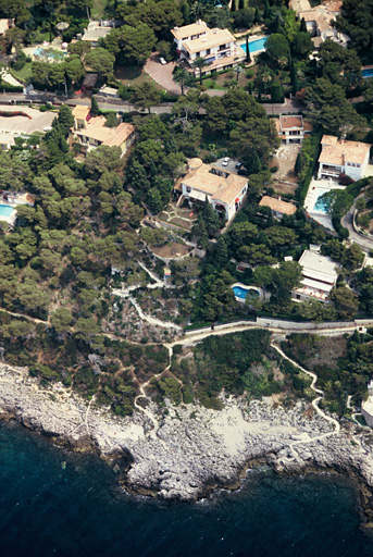 Vue aérienne prise vers l'est, montrant la villa et son jardin descendant vers la mer.