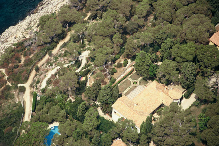 Vue aérienne prise vers le nord-ouest, montrant la villa, son jardin et la côte.