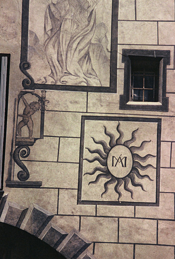 Façade sud, détail sur décor peint et monogramme de la Vierge.