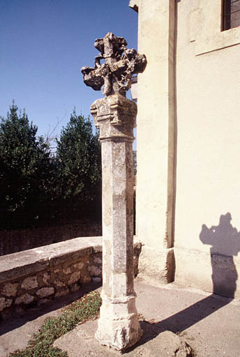 Vue générale de la croix double face datée de 1532 placée devant la façade de l'église paroissiale.