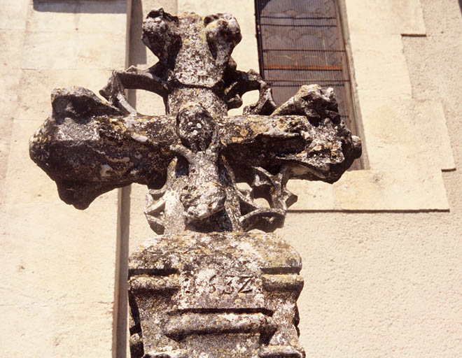 Vue de la croix double face datée de 1532 placée devant la façade de l'église paroissiale, détail.