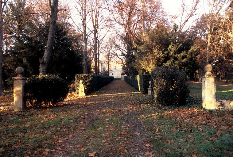 Vue du parc, l'allée de buis et la façade du château.