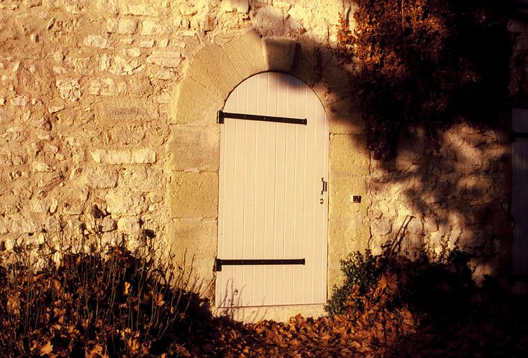 Vue des dépendances dans la cour du château, détail d'une porte en plein cintre.