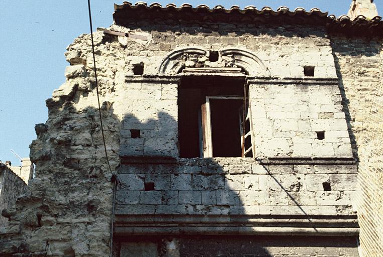 Façade est, partie haute, baie et mur romans.