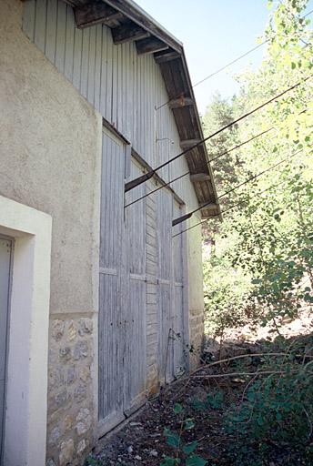 Recette inférieure, façade nord, vantaux de bois laissant filer les câbles.