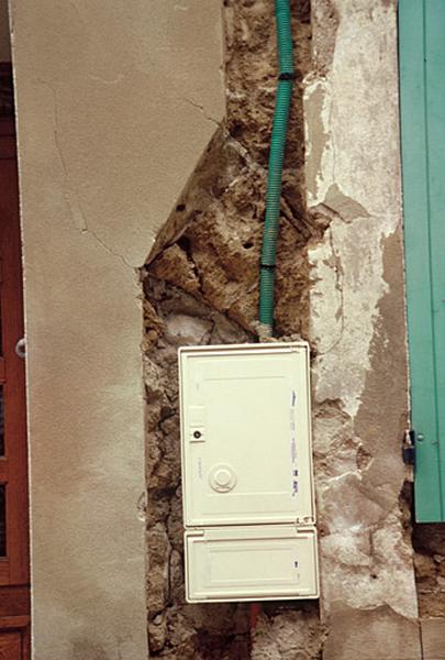 Façade principale sur rue, mur appareillé apparaissant sous l'enduit.