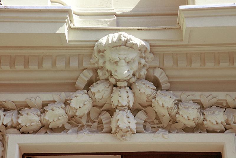 Bâtiment B, linteau de porte, guirlande et tête de lion.