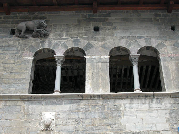 Façade principale, baies géminées et relief sculpté : lion dévorant une chèvre.