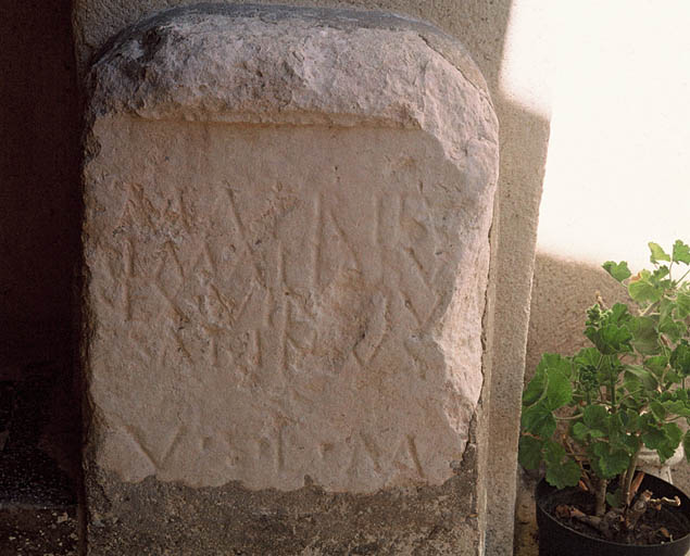 Stèle romaine avec inscription sur le montant du porche.