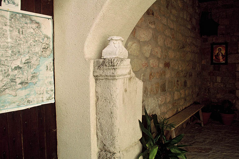 Stèle romaine avec inscription sur le montant du porche.