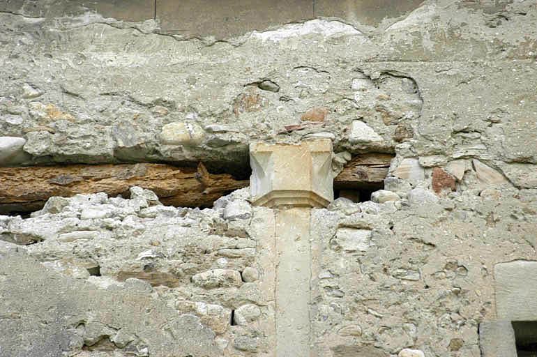 Cloître, aile ouest, galerie bouchée du premier étage, colonnette et chapiteau.