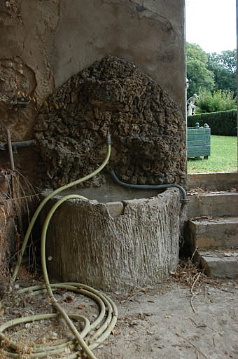Vue de la serre, détail du puits en rocaille.
