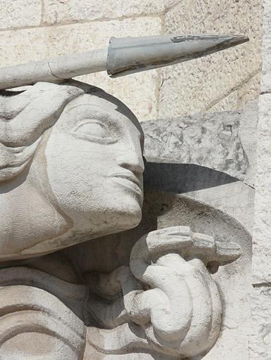 Façade du monument, partie gauche, haut-relief : la guerre, visage de droite.