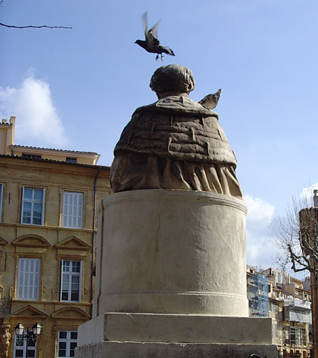 Vue d'une des deux statues devant la façade du palais de justice, de dos.