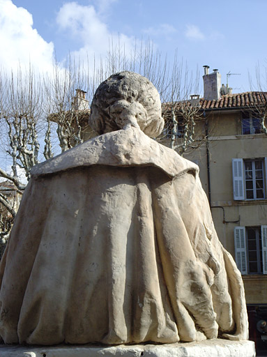 Vue d'une des deux statues devant la façade du palais de justice, de dos.