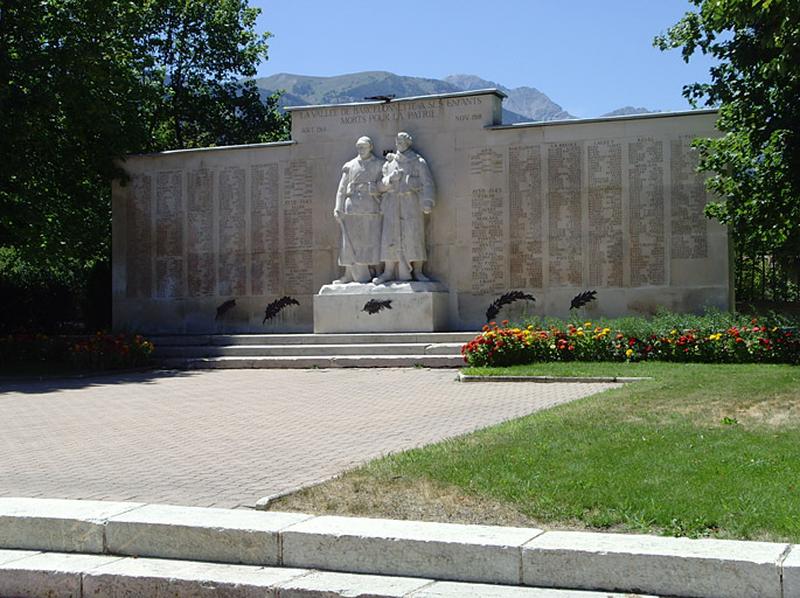 Vue générale, au premier plan les deux premières marches qui délimite un podium. Au fond, derrière le monument, apparaissent les montagnes à la manière d'un fond d'écran.