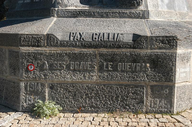 Vue de l'inscriptions sur le socle de la pyramide, face sud : " PAX GALLIAE " et " A SES BRAVES LE QUEYRAS... " et de part et d'autre " 1914-1918 "et 1939-1945 ".