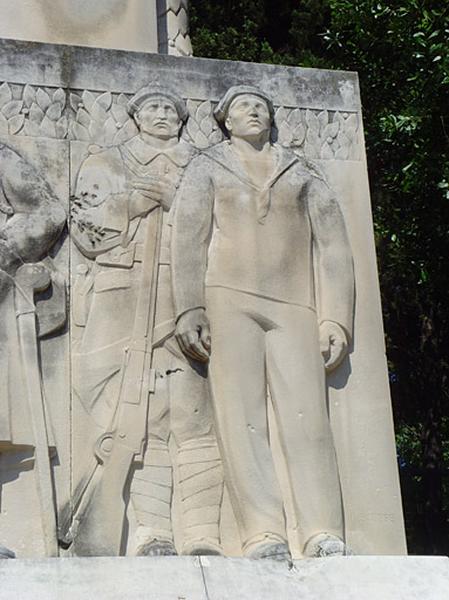 Vue la partie latérale droite du monument, deux marins, un fusillier marin en manteau relevé avec son fusil et un marin en vareuse.